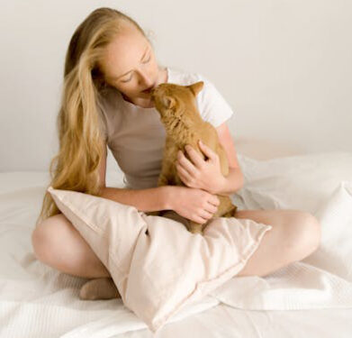 Gato saliva - Foto de Alina Skazka: https://www.pexels.com/es-es/foto/mujer-cama-animal-besando-24740464/